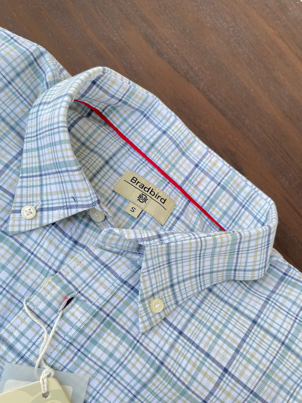 Green-blue plaid oxford shirt collar with size tag and red inner trim