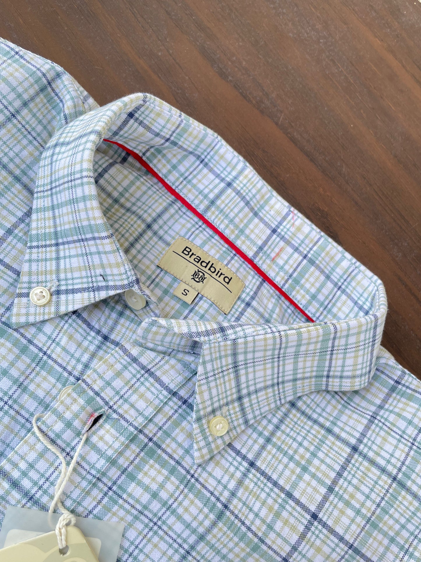 Green-blue plaid oxford shirt collar with size tag and red inner trim