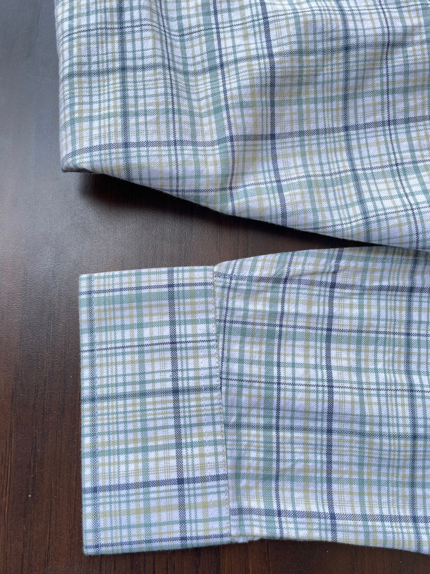 Folded green-blue plaid oxford check shirt cuff and hem