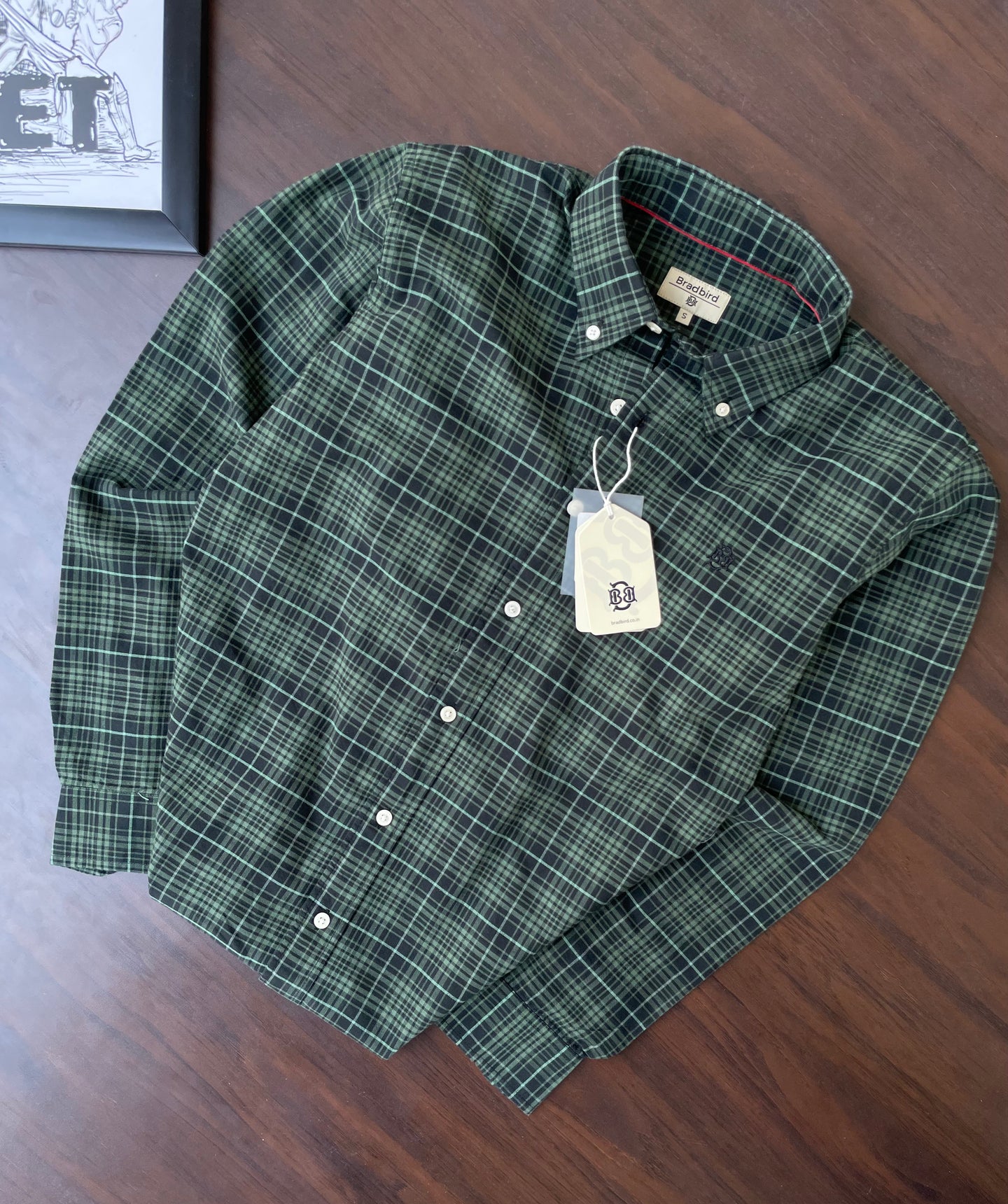 Folded green check oxford shirt with white buttons and pointed collar
