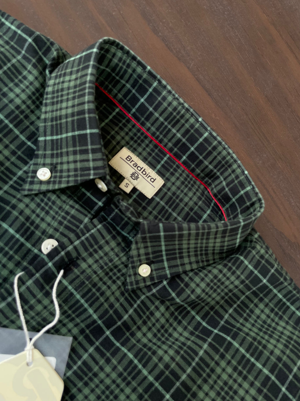 Green plaid button-up shirt collar with Bradbird label on inside neckline