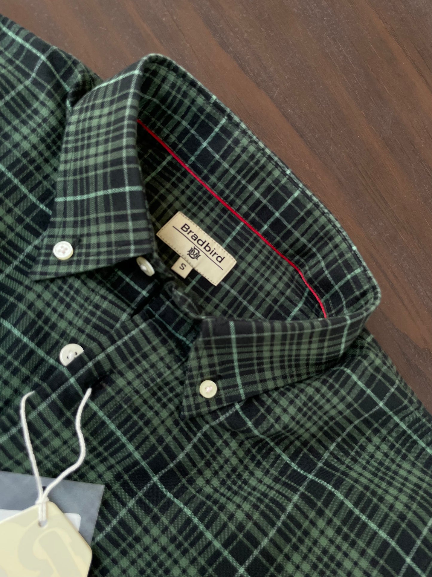 Green plaid button-up shirt collar with Bradbird label on inside neckline