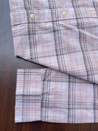 Pink oxford check shirt hem and sleeve cuffs with white buttons, folded