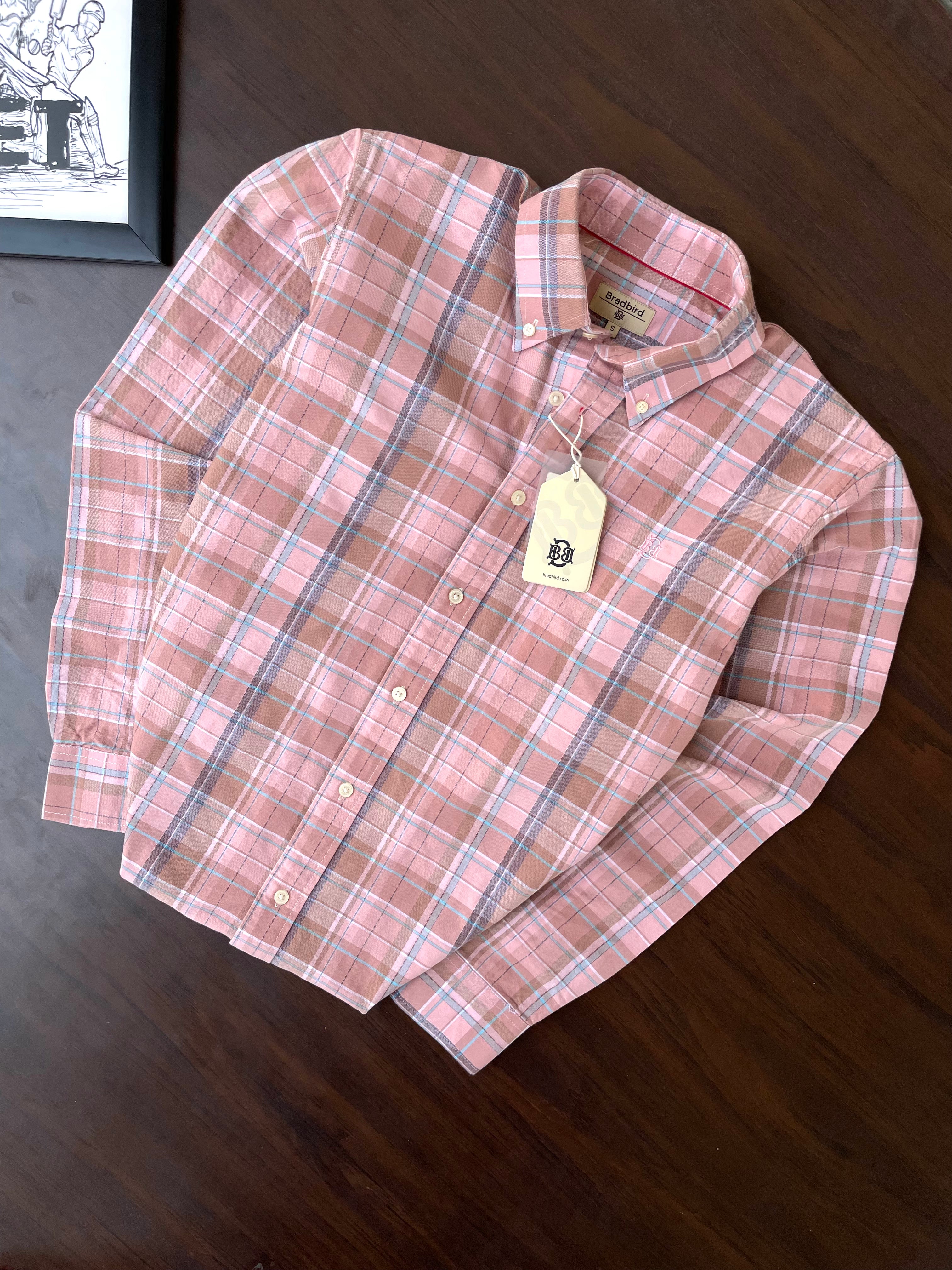 Folded pink plaid oxford button-up shirt with tag on collar