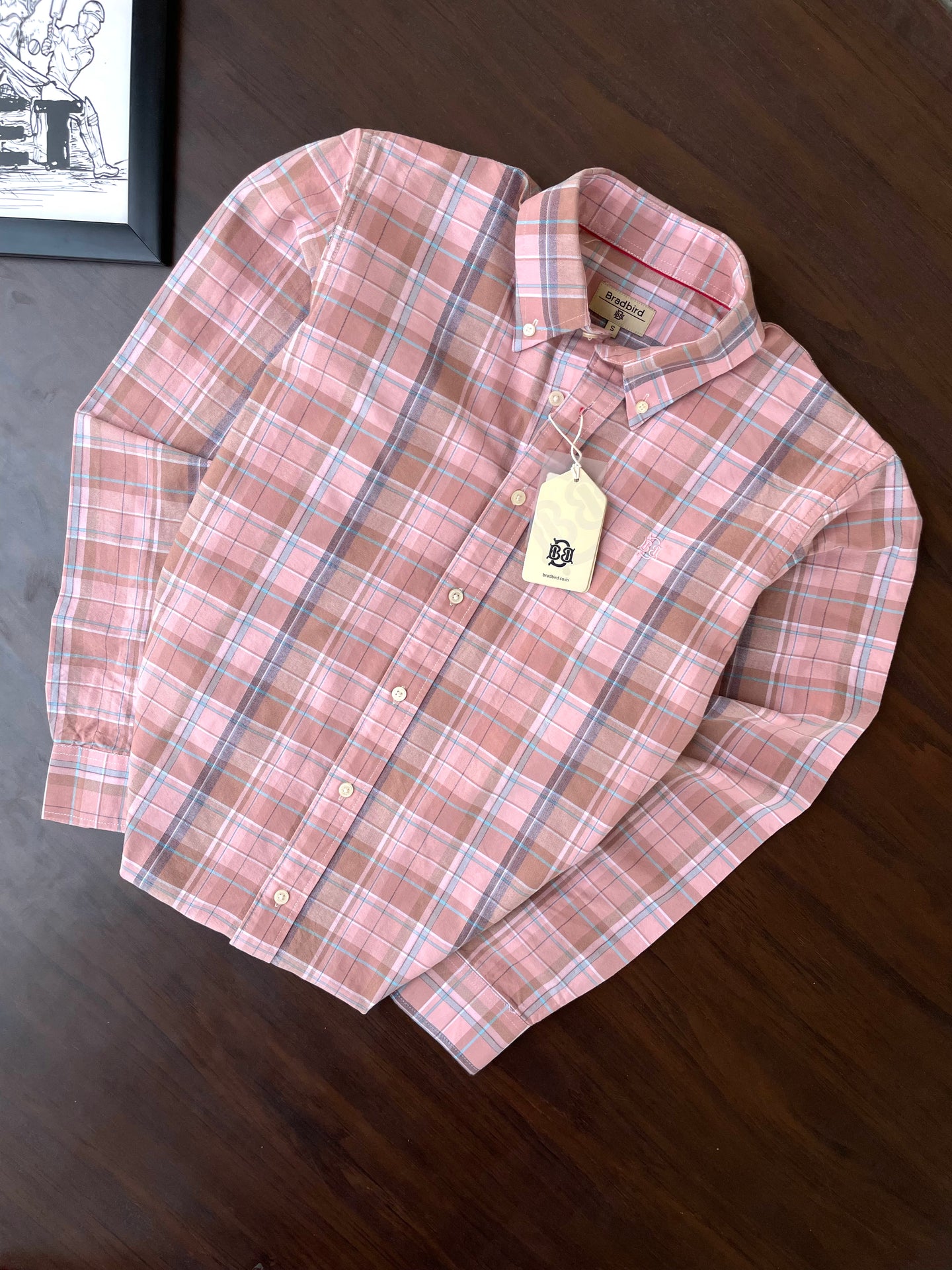 Folded pink plaid oxford button-up shirt with tag on collar