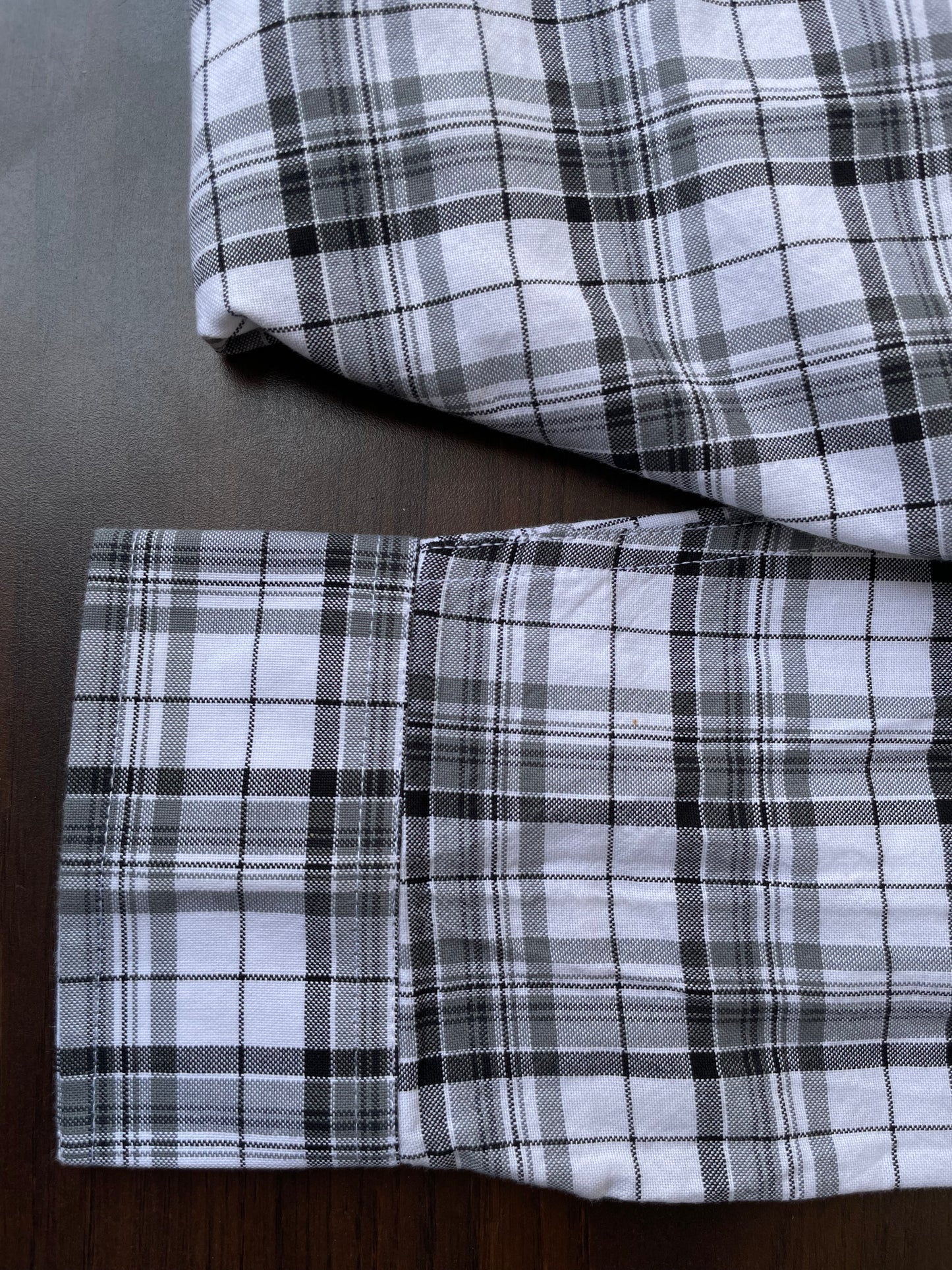 Black-and-white plaid shirt sleeve and cuff with folded hem detail