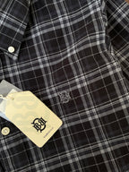 Black check Oxford shirt close-up: white buttons and embroidered chest logo