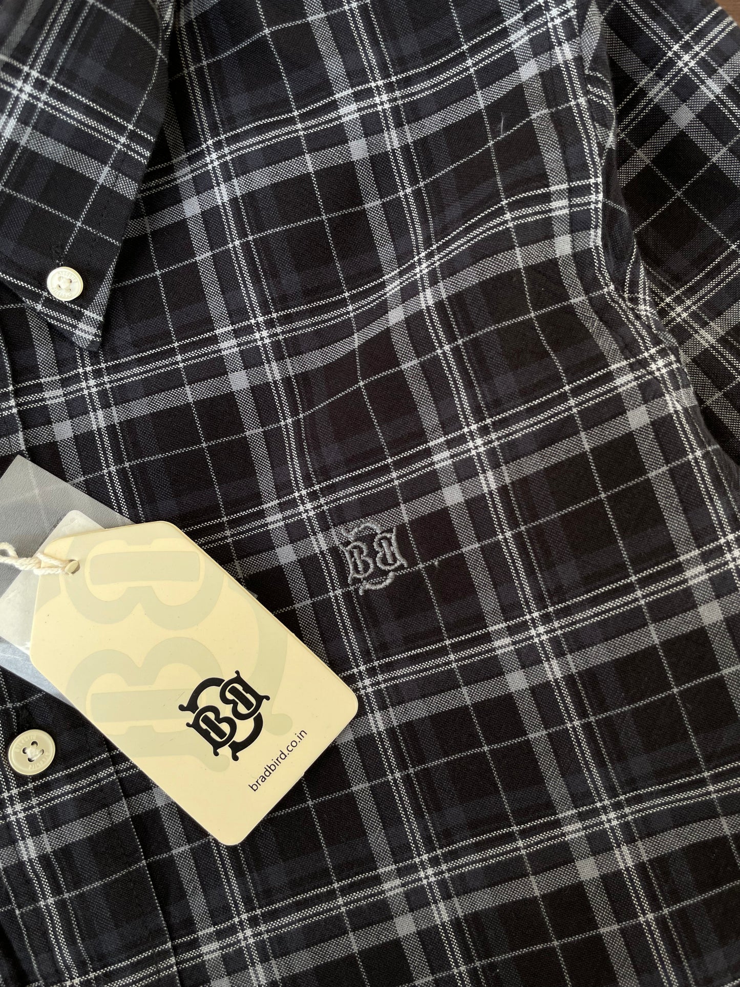 Black check Oxford shirt close-up: white buttons and embroidered chest logo