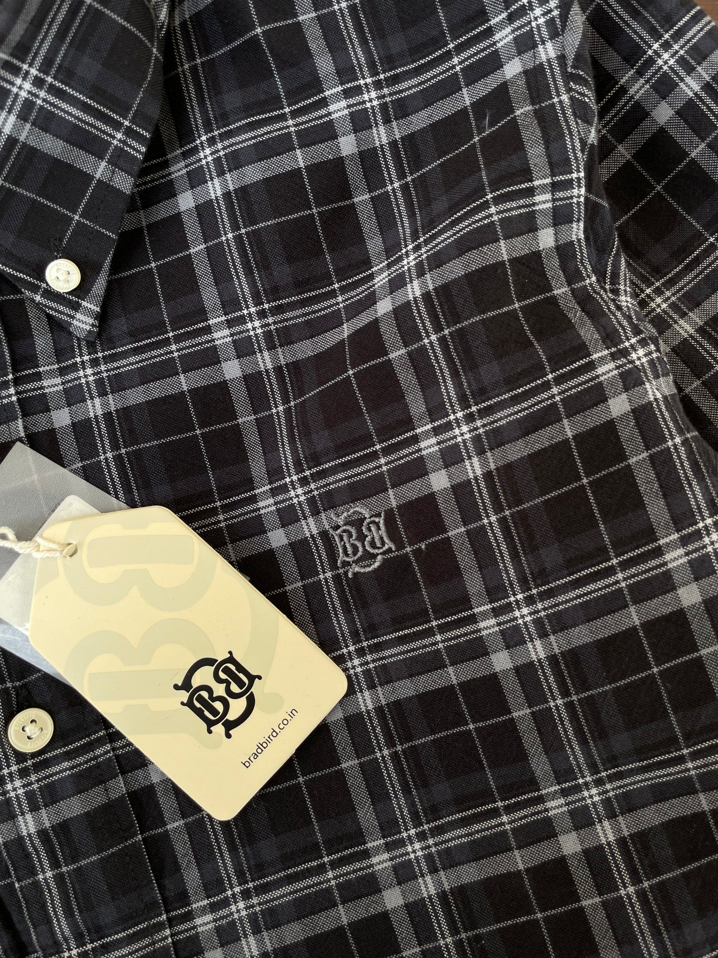 Black check Oxford shirt close-up: white buttons and embroidered chest logo