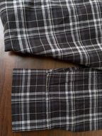 Black plaid shirt cuffs and hem in folded view, stitched check pattern