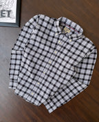Black-and-white plaid oxford shirt, folded with long sleeves, collar, and buttons