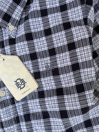 Black-and-white plaid shirt chest detail with small stitched emblem and button