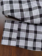 Black-and-white check oxford shirt cuff and hem, showing stitched seams