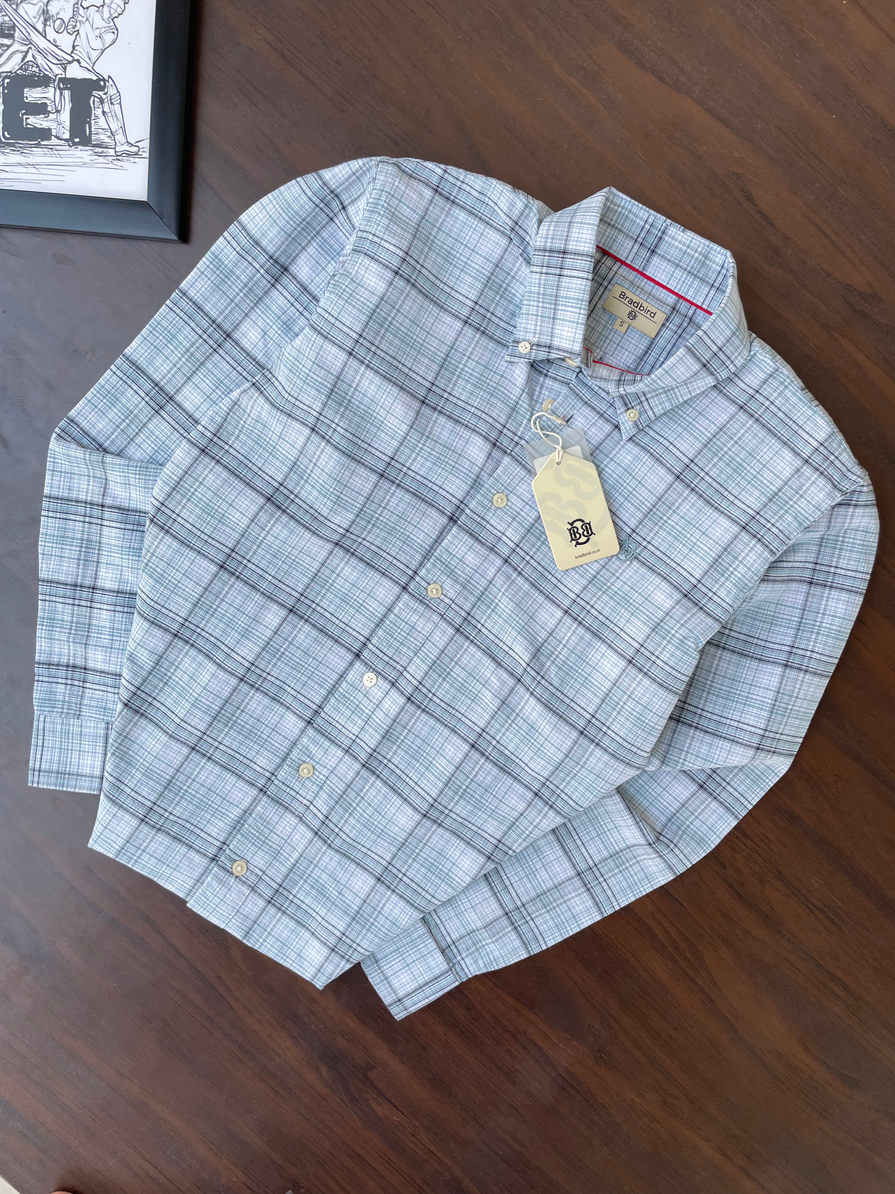 Folded mint-blue oxford check button-up shirt with collar and hanging tag