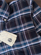 Close-up of navy blue check Oxford shirt with white buttons and hang tag