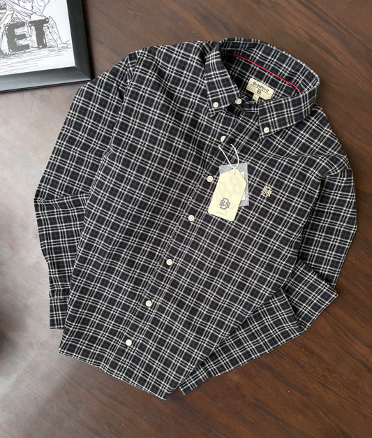Folded dark checkered button-up shirt with white plaid pattern and collar tags