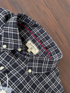 Close-up of dark plaid shirt collar with white check lines and button placket