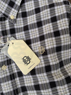 Close-up: black-and-beige plaid Oxford shirt, gold-tone buttons, button-down collar