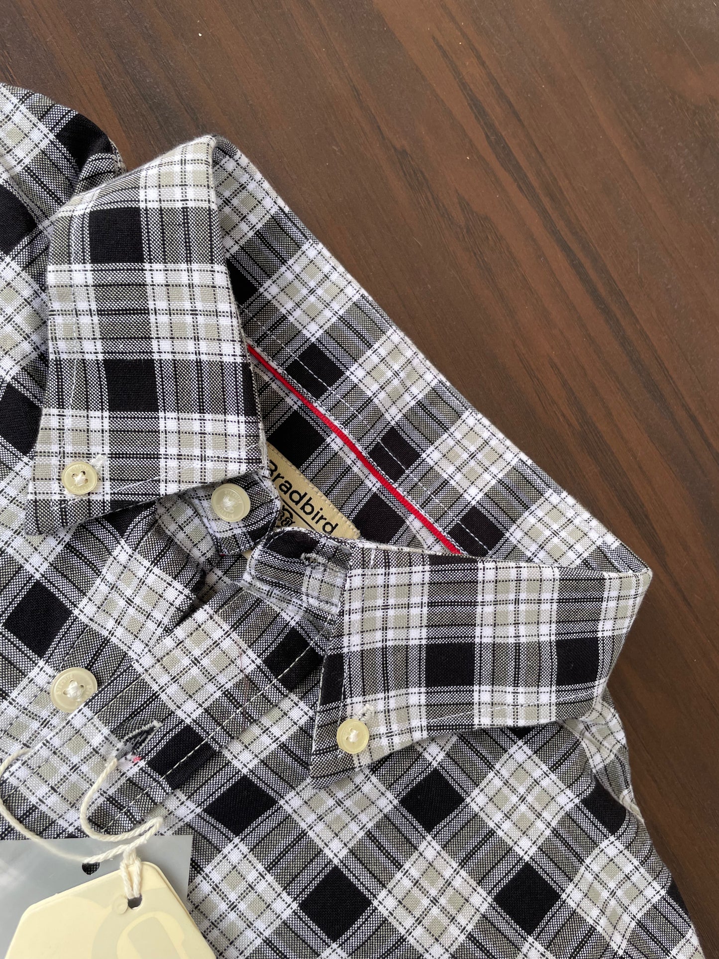 Folded black-and-beige plaid Oxford shirt, pocket flap and button cuffs