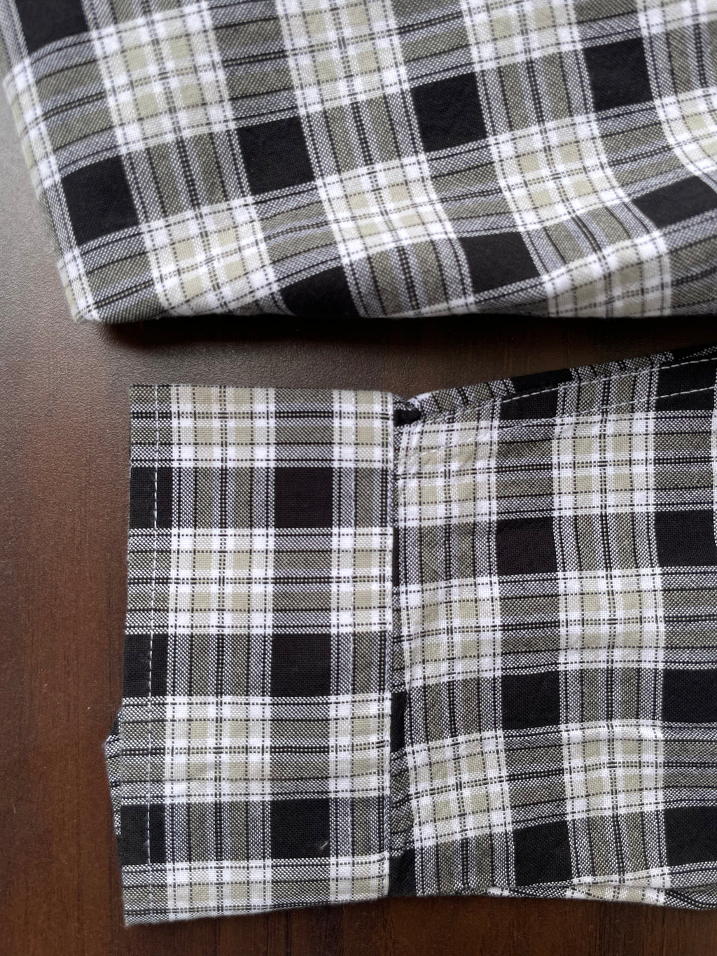 Black-and-beige plaid Oxford shirt cuffs and folded hem, button placket