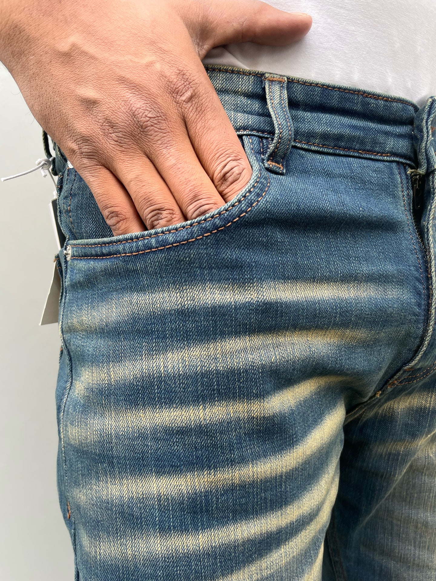 Back pocket close-up on medium-wash straight jeans with contrast stitching