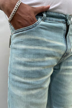Close-up of light wash denim back pocket and stitched waistband