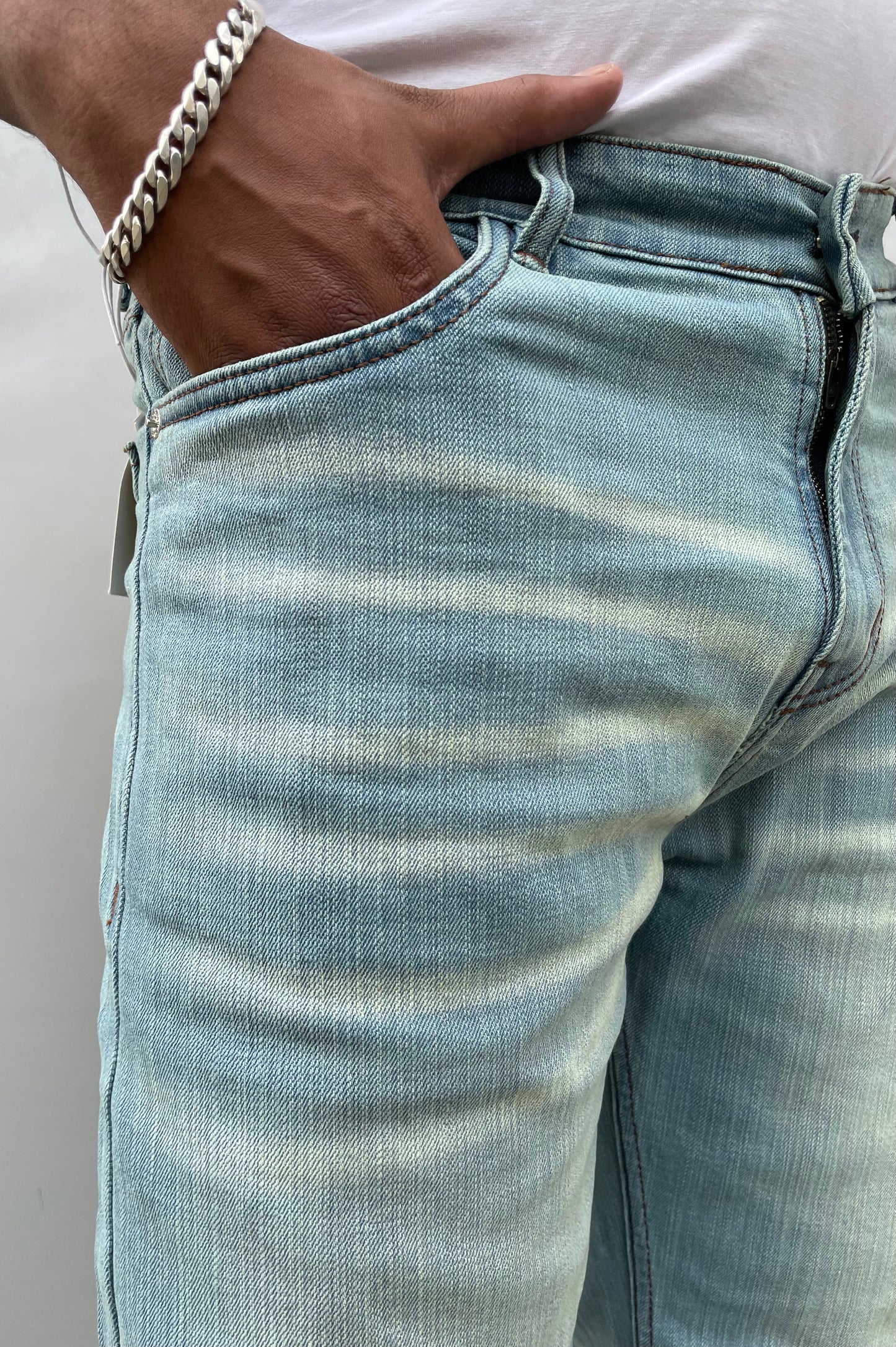 Close-up of light wash denim back pocket and stitched waistband
