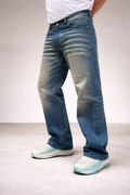Straight-fit jeans side view, medium indigo wash with whisker detailing along the thigh