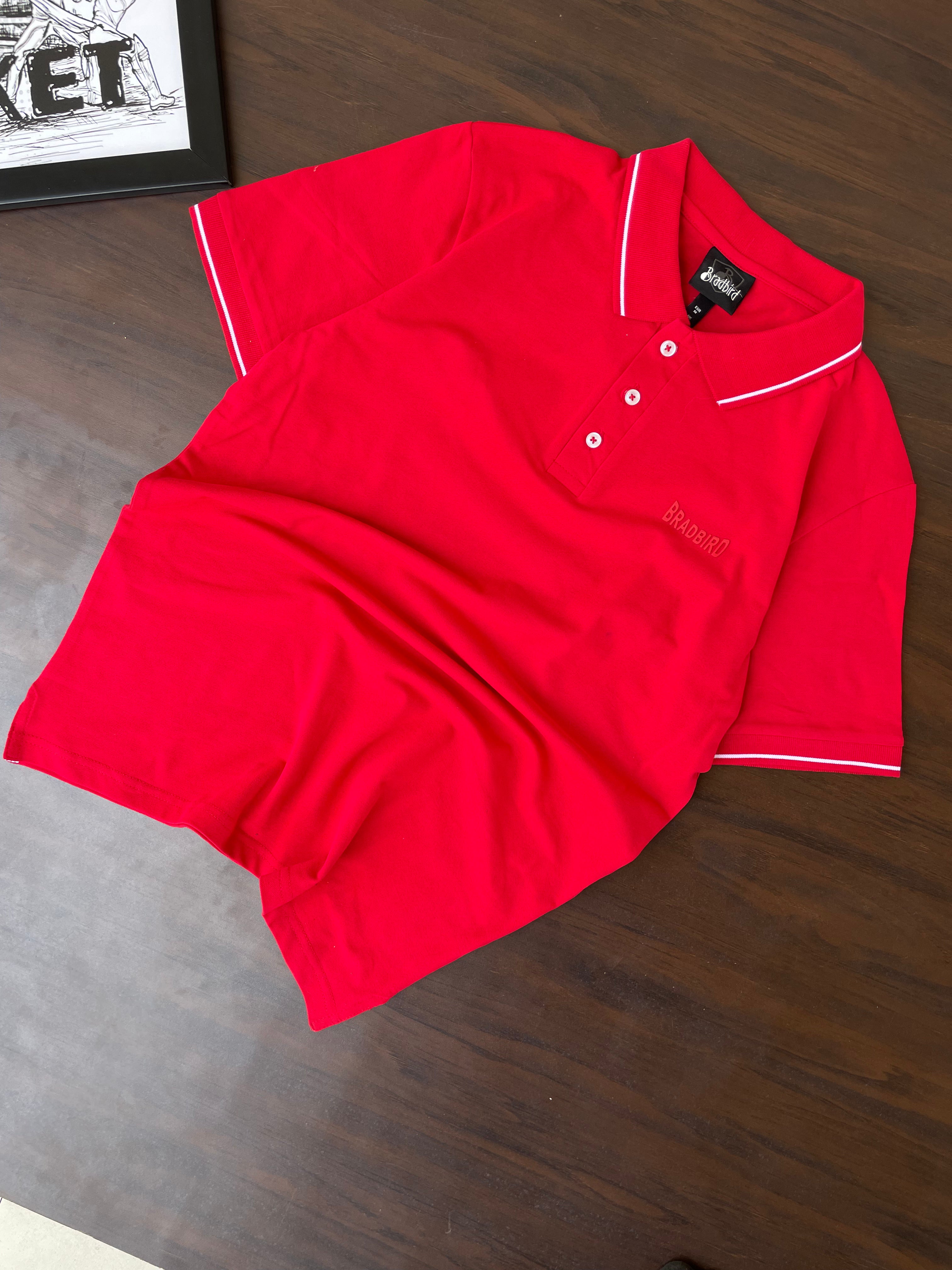 Folded red polo shirt with white button placket and collar tipping detail