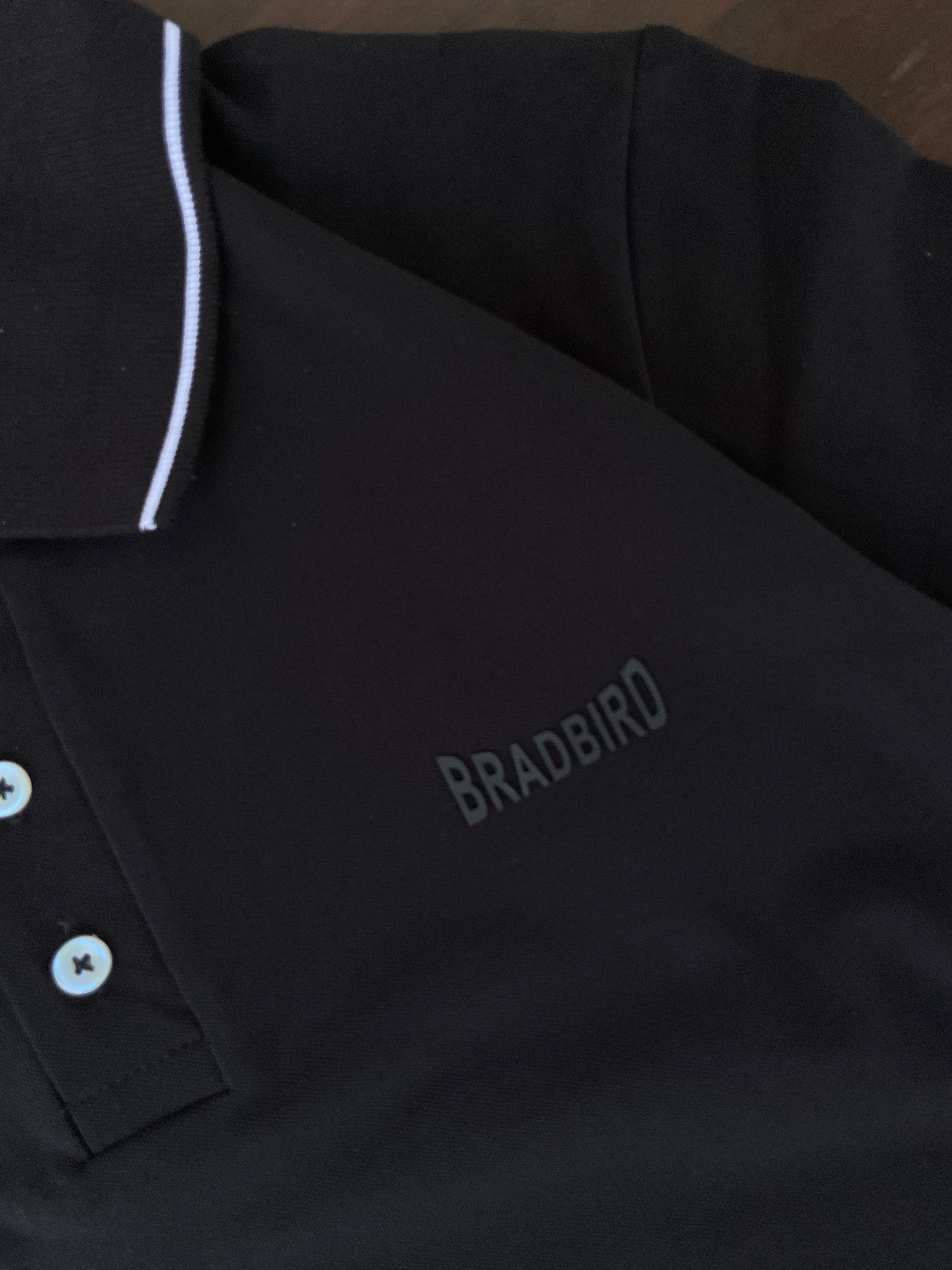 Black polo shirt close-up: white collar edge, button placket, embroidered logo