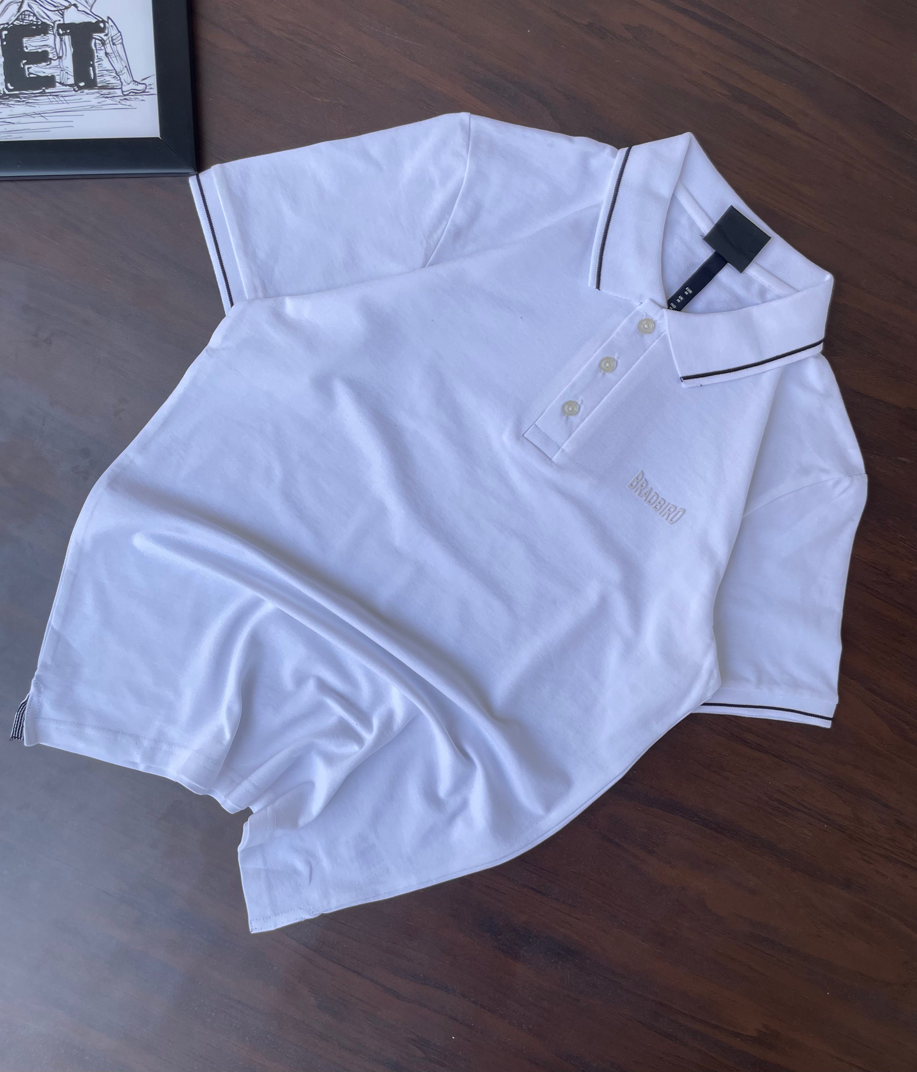 White polo shirt laid flat, black-trim collar and short sleeves, button placket visible.