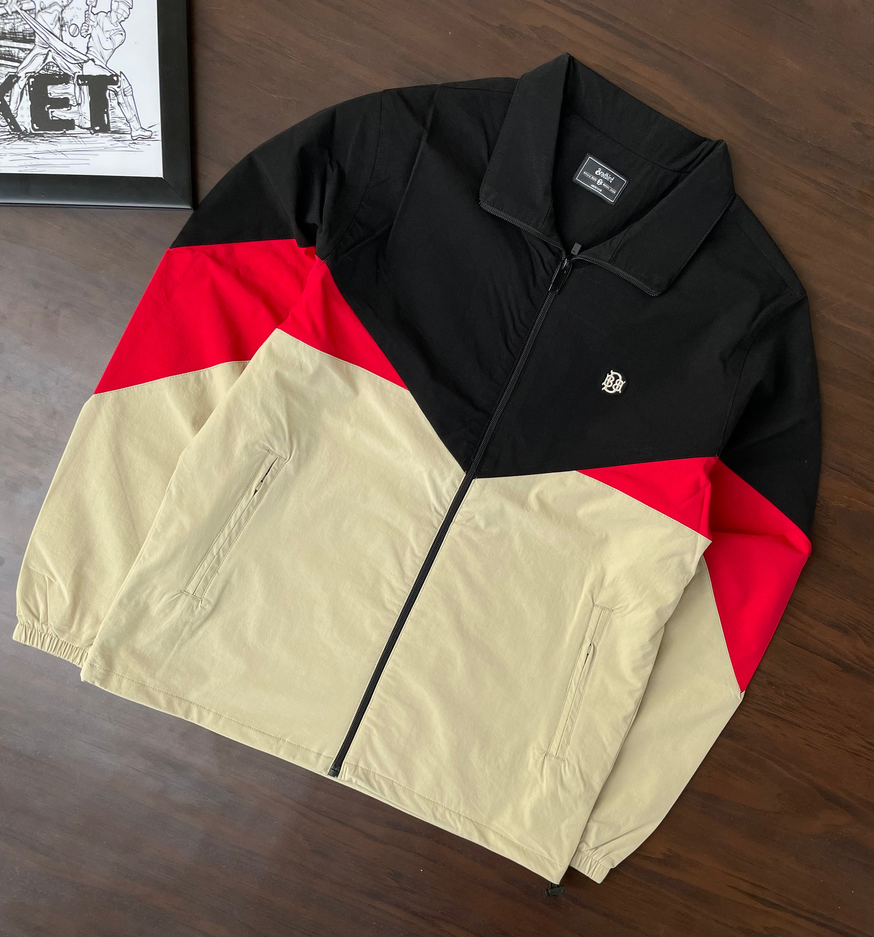 Black, red and sand color-block windbreaker jacket, flat lay, full front view with zipper