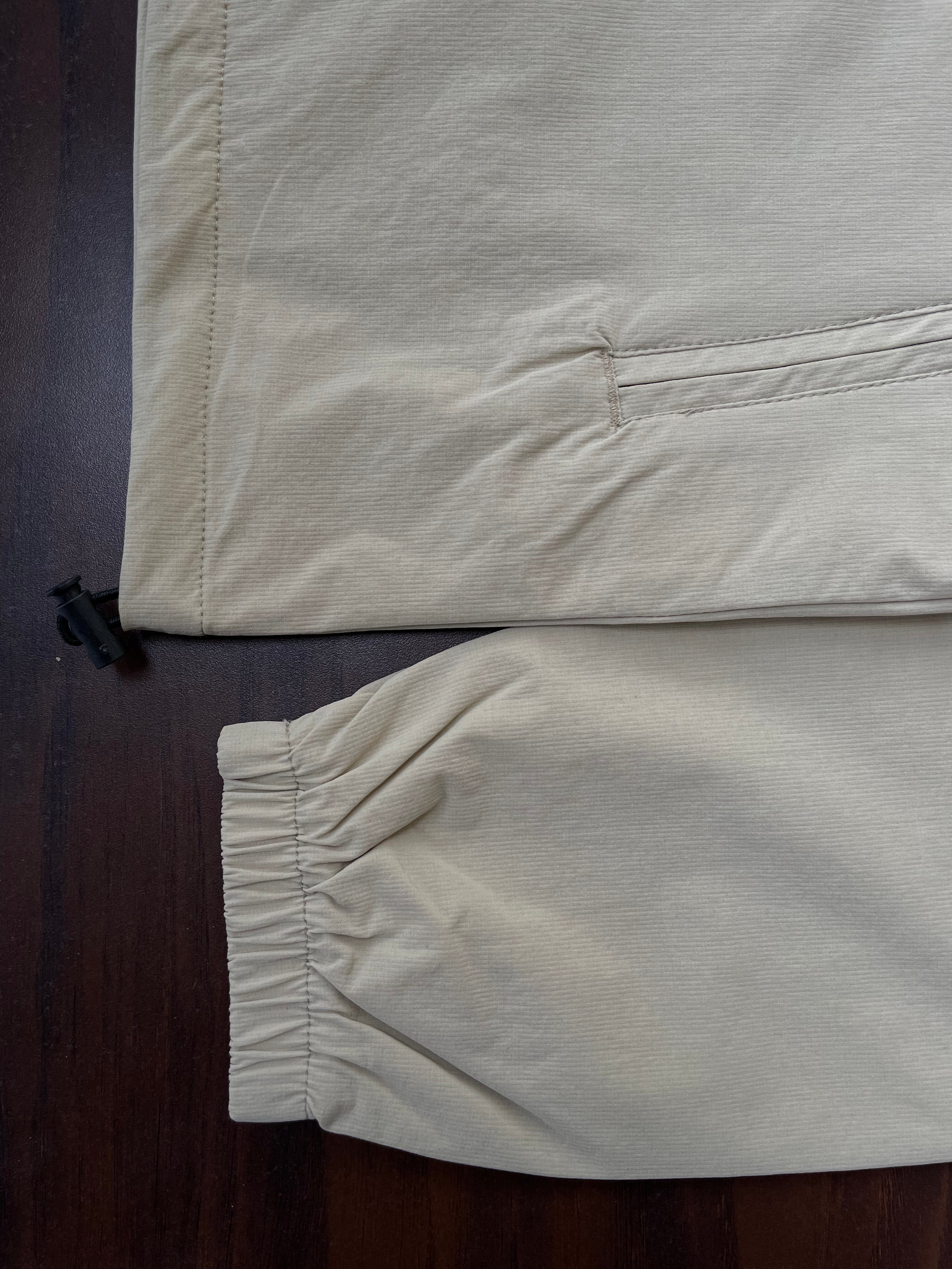 Sand windbreaker cuff and hem detail with elastic gathering; zipper end