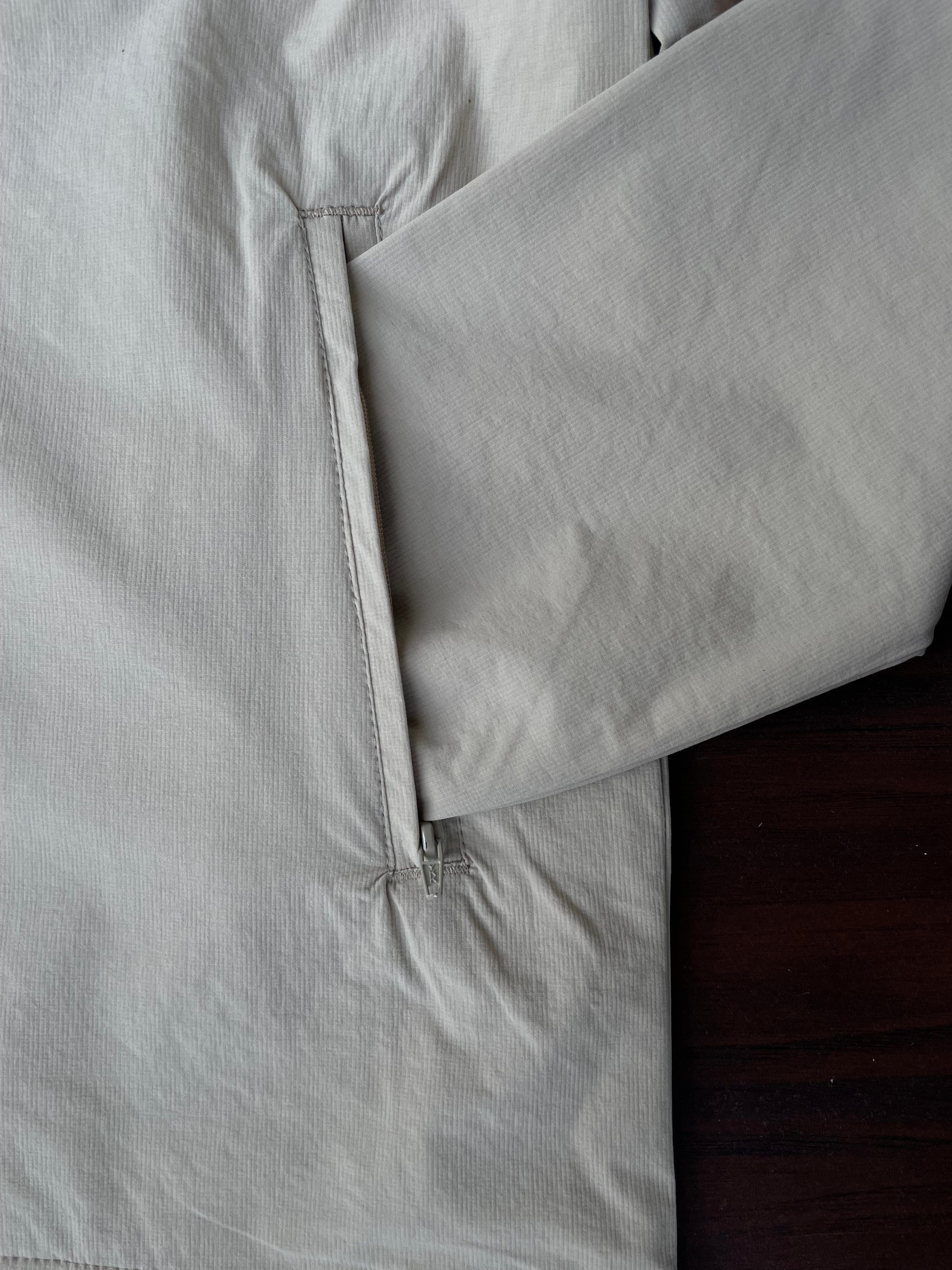 Sand windbreaker sleeve and side seam with button-snap placket detail