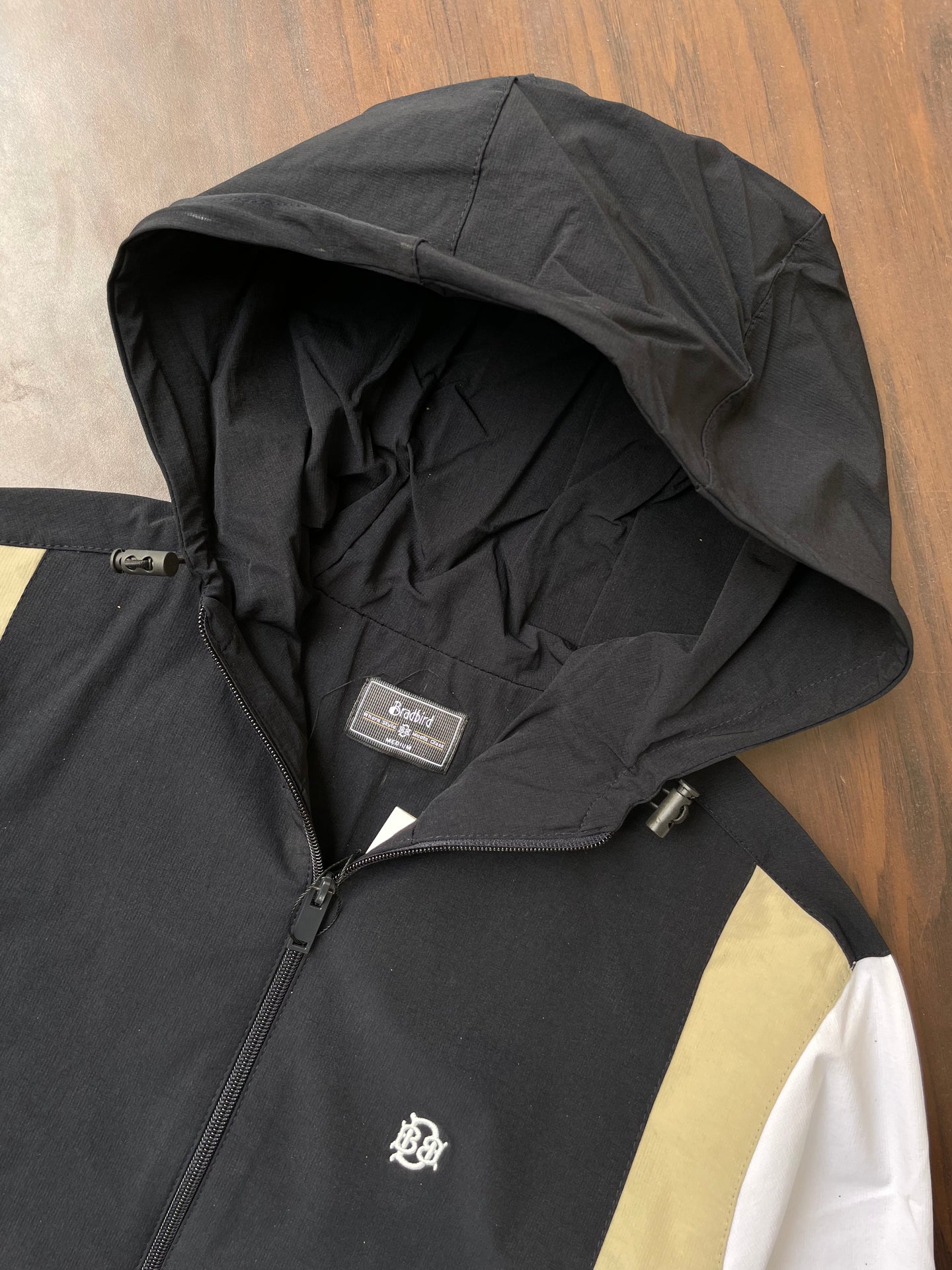Black hooded windbreaker with inner hood and tag, sand and white side panel