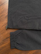 Black windbreaker hem and sleeve cuff with elastic edge and stitched seam