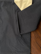 Black windbreaker side zipper pocket area with sand and white panel insert