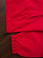 Scarlet red windbreaker hem with elastic cuffs, close-up on front and sleeve
