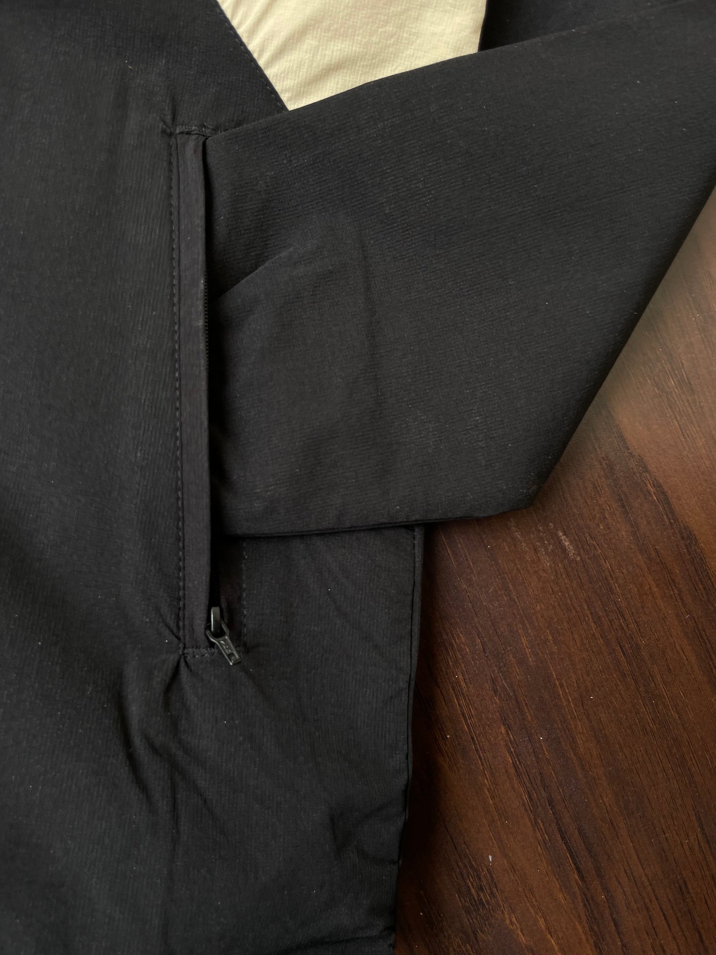 Black windbreaker side seam and zipper with pocket opening and elastic cuff