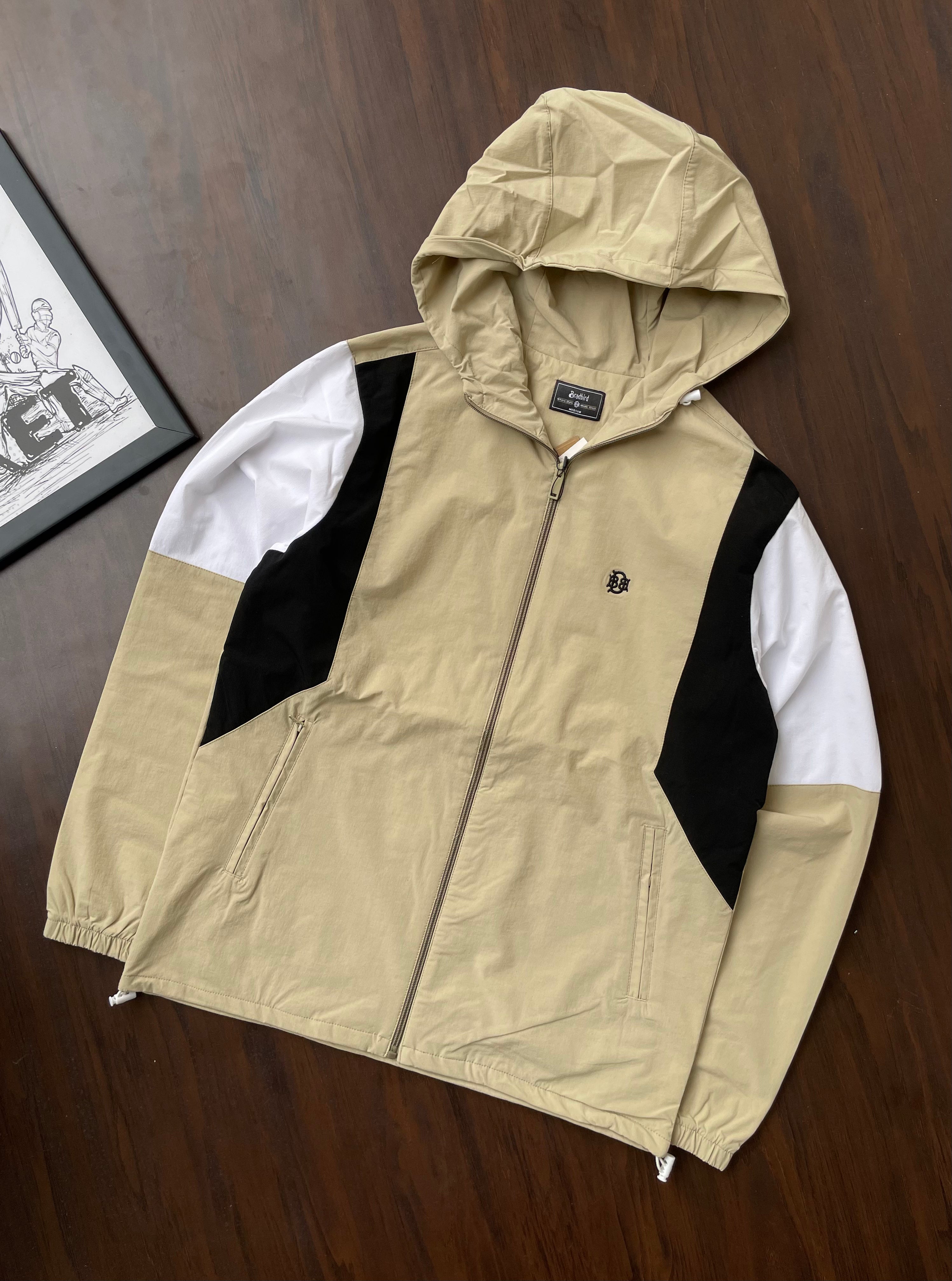 Sand hooded windbreaker with white-and-black side panels, full zip front