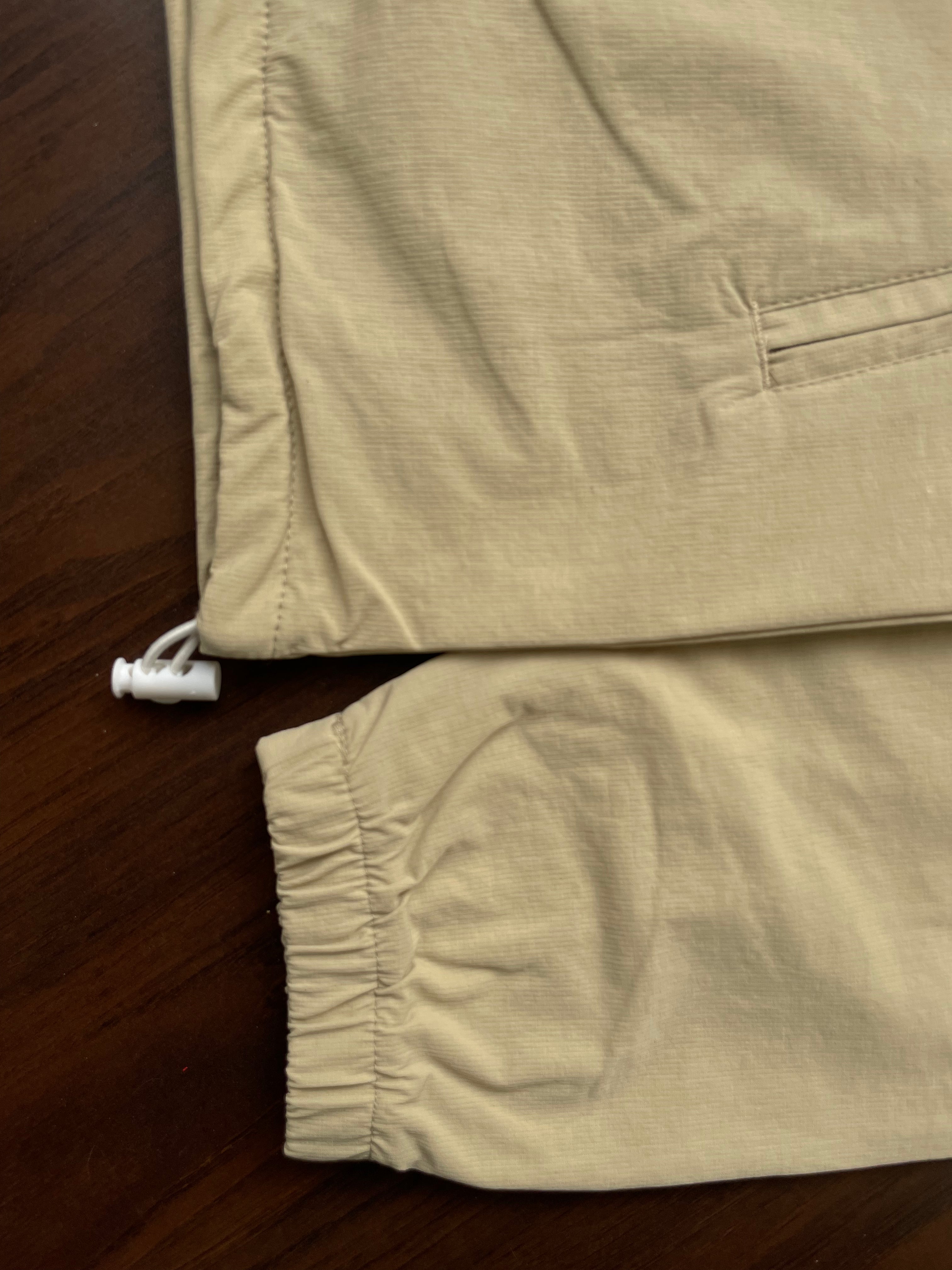 Desert sand windbreaker hem detail with gathered cuffs and white drawstring