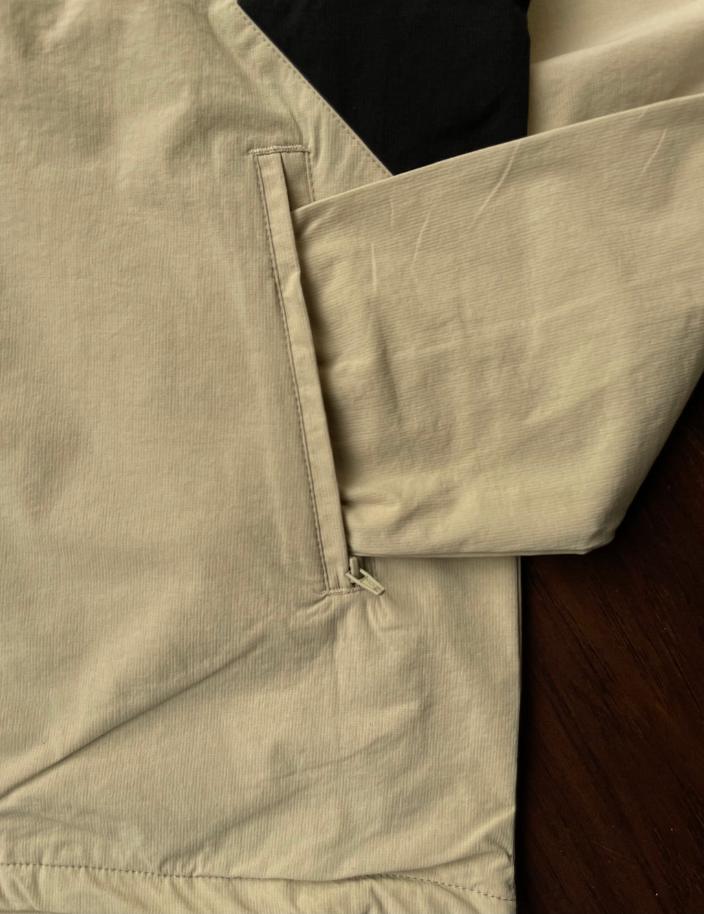 Desert sand windbreaker pocket and cuff close-up with black lining