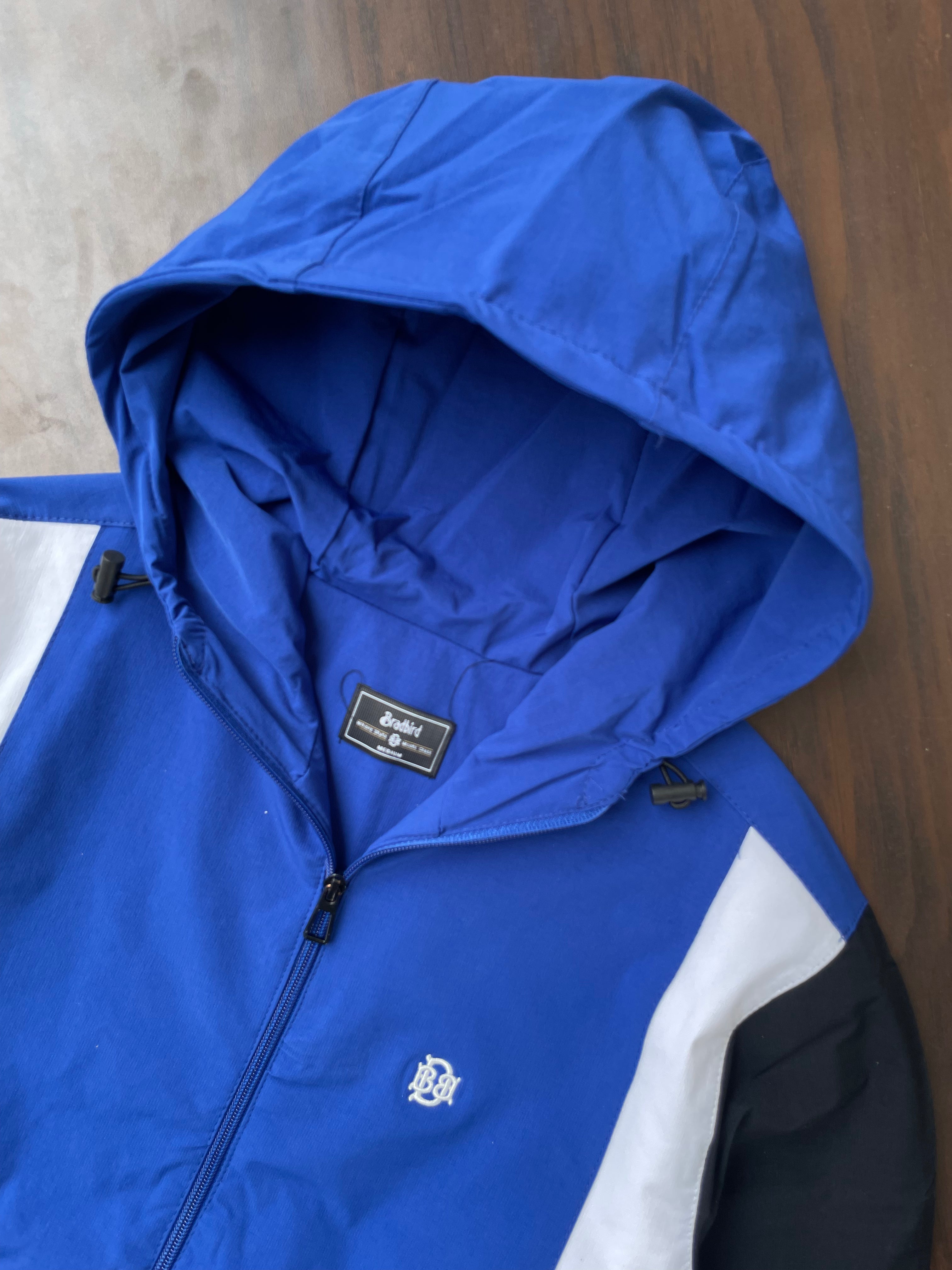 Blue hooded windbreaker hood interior with front zipper and chest logo