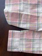 Dusty pink plaid western shirt cuff area with buttoned sleeve opening