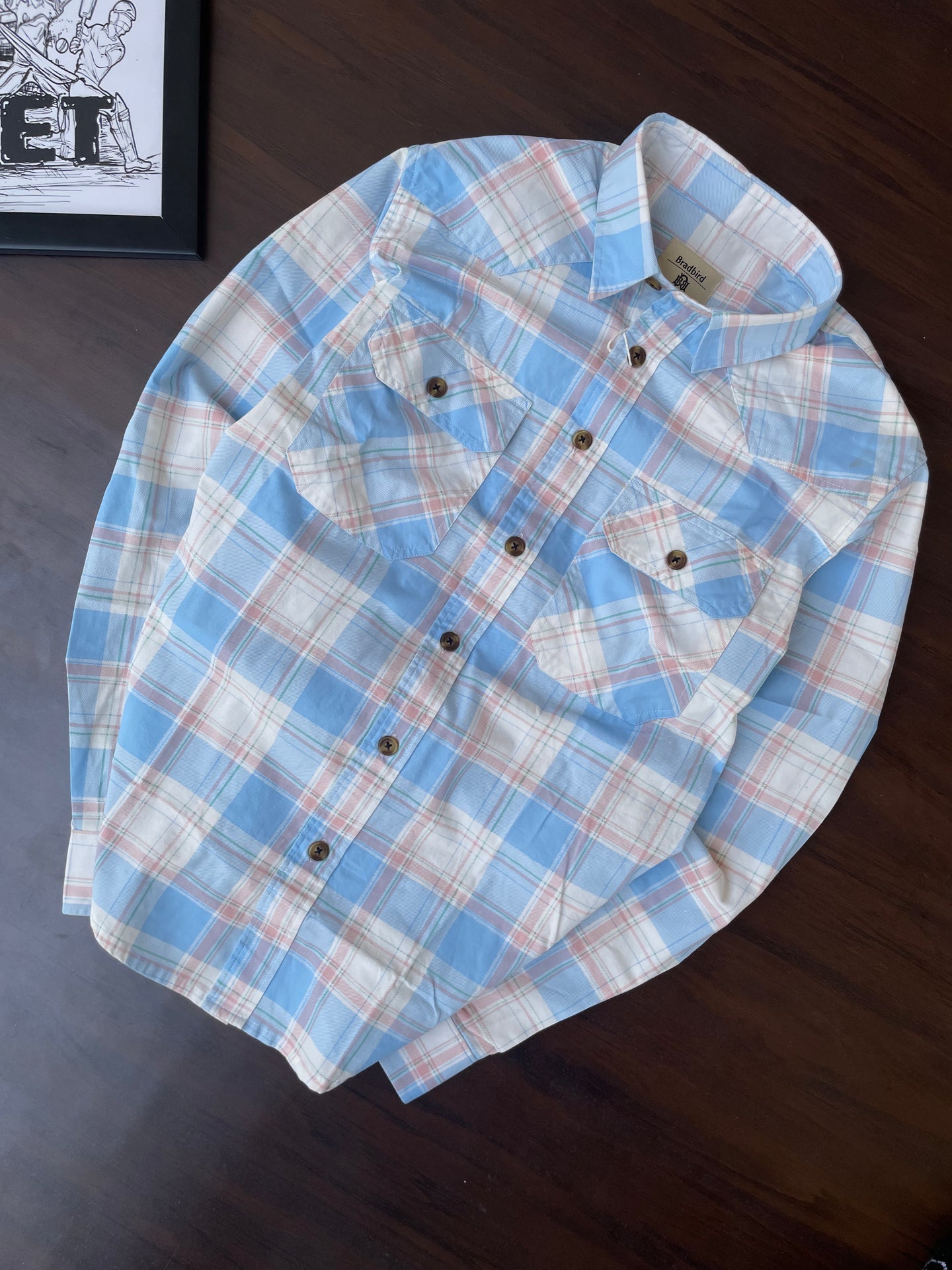 Folded sky blue plaid western shirt with two chest pockets and buttoned placket