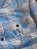 Front pocket and snap buttons on sky blue plaid western shirt