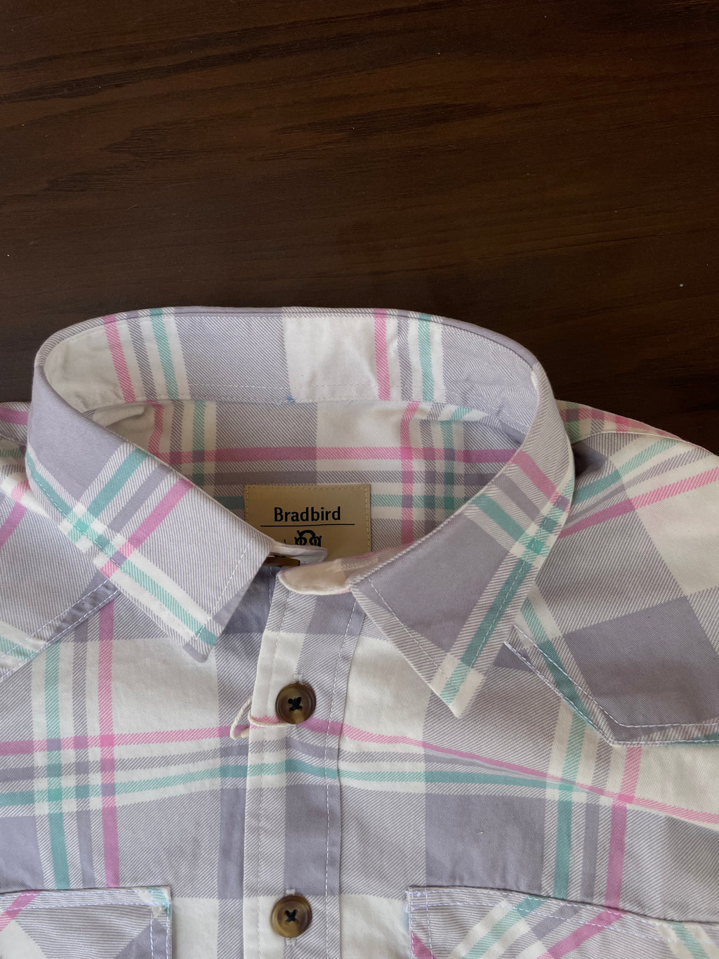 Placket and collar view of lavender and grey plaid western shirt, buttoned