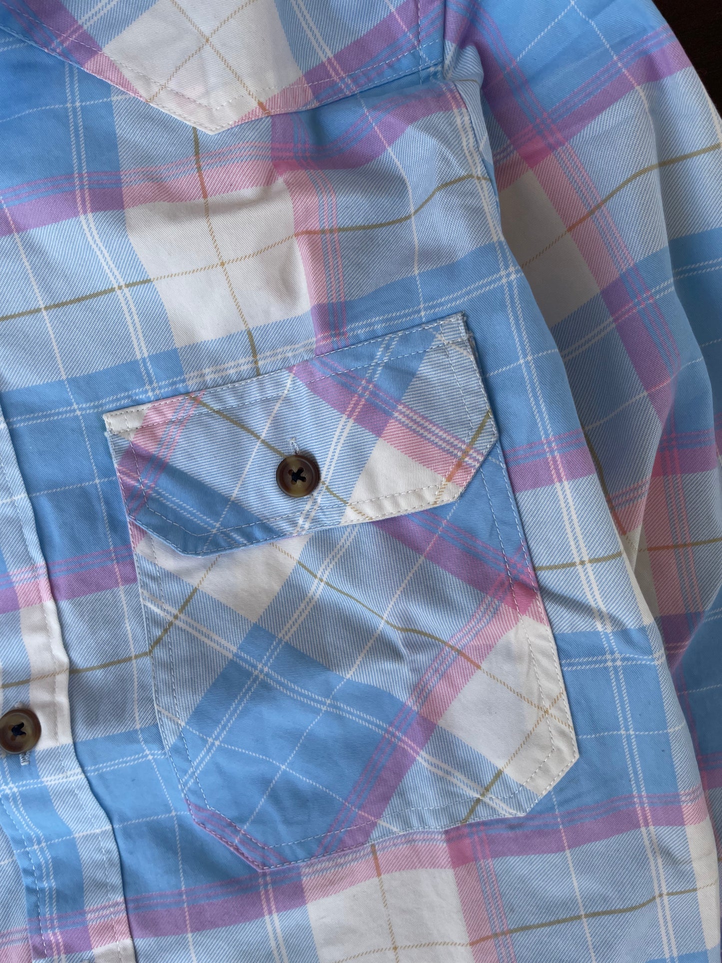 Chest pocket detail on sky blue plaid western shirt with candy pink accents