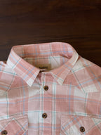 Peach-and-white plaid western shirt close-up: button collar and two chest pockets