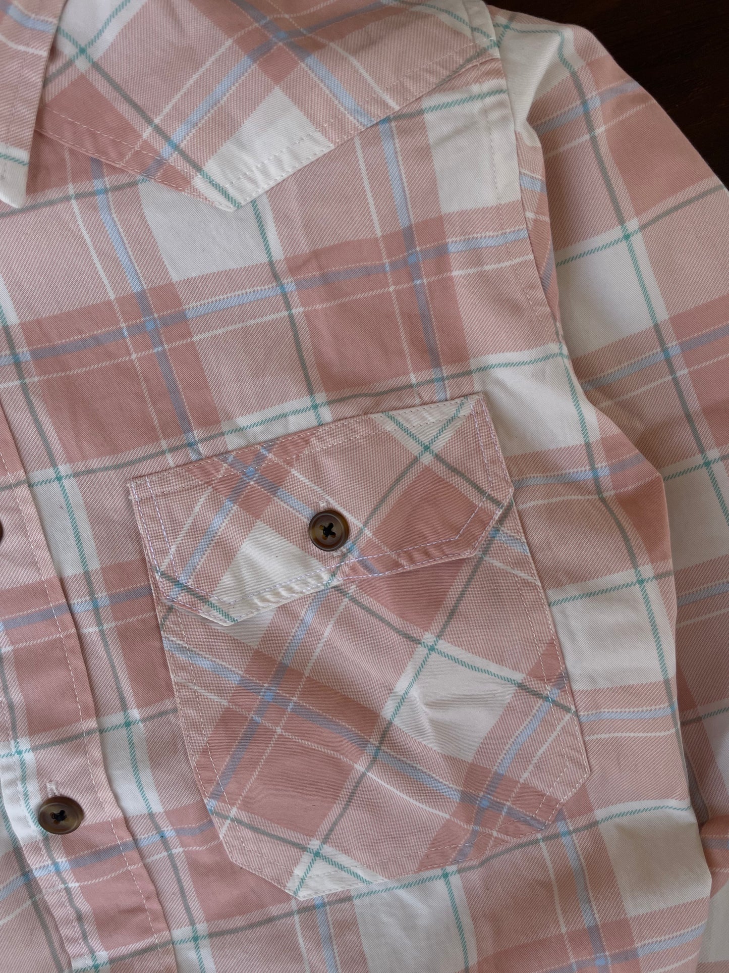 Peach plaid western shirt detail with button front and flap chest pockets
